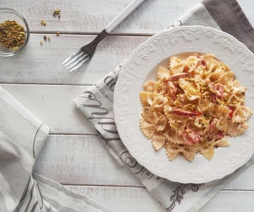 Farfalle mit Parmesansauce, Speck und Pistazien