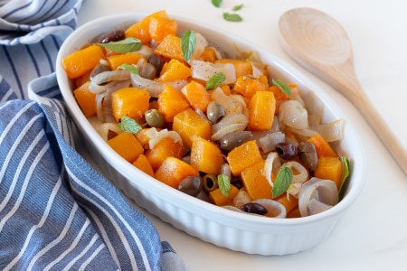 Kürbis in der Pfanne mit Zwiebeln und Oliven