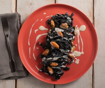 Tagliatelle mit Sepia-Tinte mit Pecorino, Miesmuscheln und Lardo