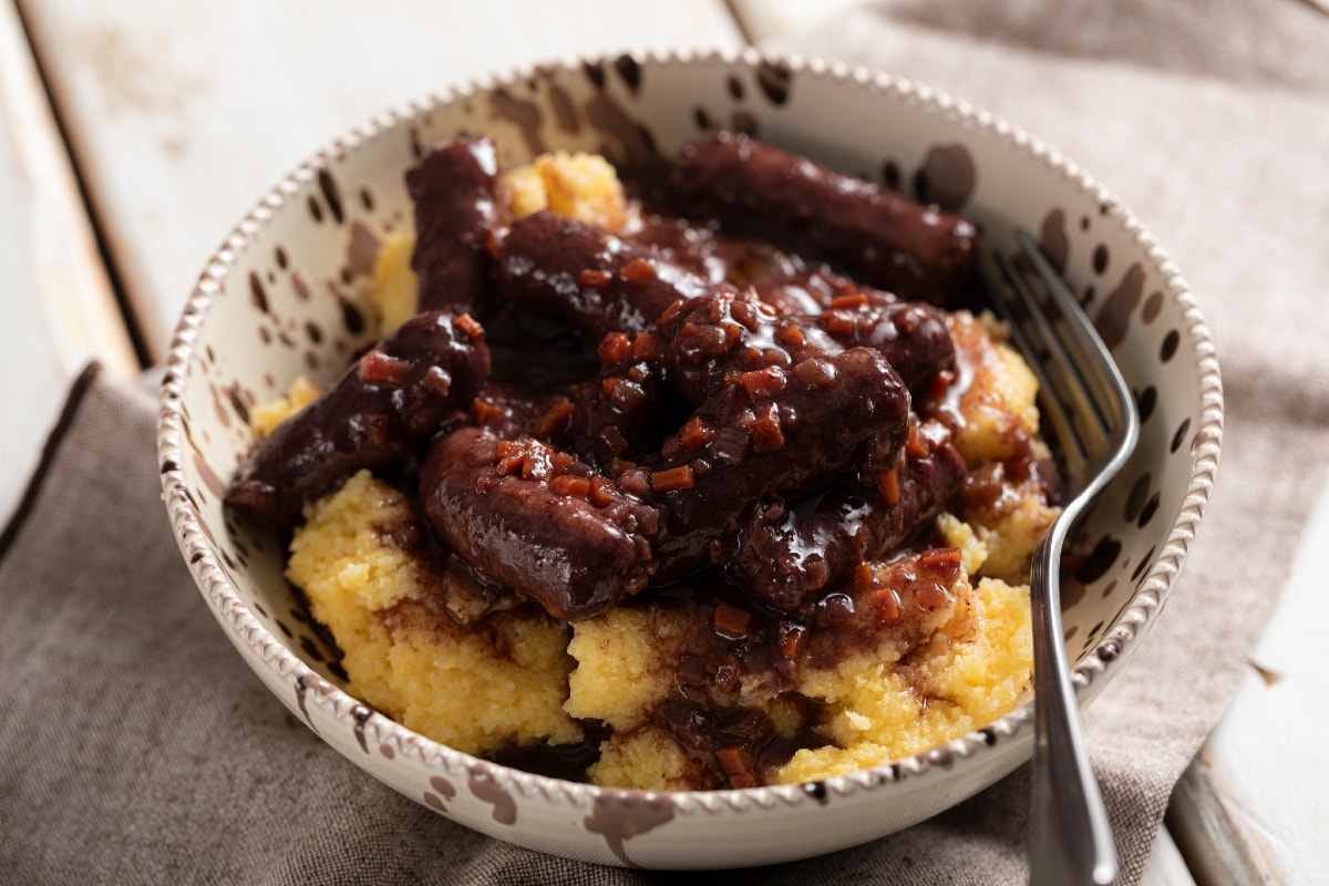 Wurst in Rotwein mit Polenta