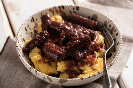 Wurst in Rotwein mit Polenta