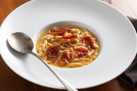 Passatelli mit Schinken in Fleischbrühe