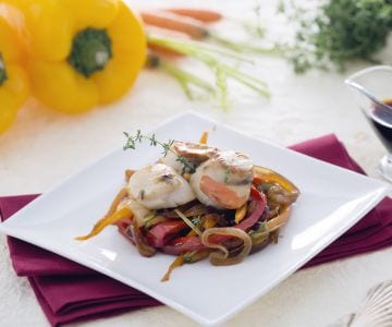 Jakobsmuscheln auf einem Bett aus karamellisierten Zwiebeln mit Karotten und Paprika in Sojasauce