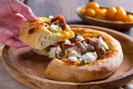 Pizza mit gelben Kirschtomaten, Sardellen und Kapern