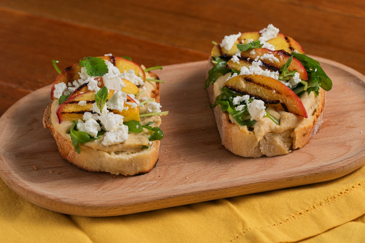 Crostone mit Hummus, gegrillten Pfirsichen, Feta und Rucola