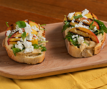 Crostone mit Hummus, gegrillten Pfirsichen, Feta und Rucola