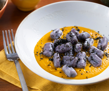 Lila Kartoffelgnocchi mit Kürbiscreme und Schwarzkohl