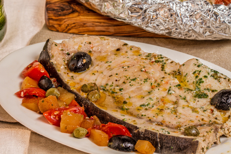 Biergeschmortes Schwertfischfilet mit Tomaten und Oliven im Päckchen