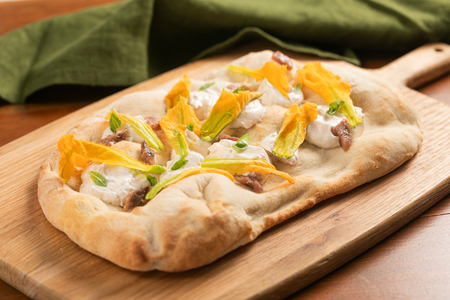 Pinsa mit Zucchiniblüten, Sardellen und Käsecreme