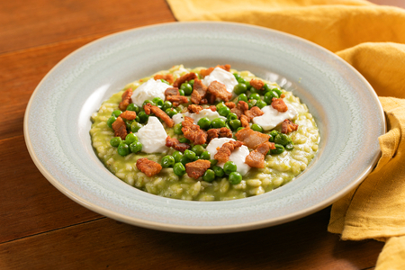 Cremiges Erbsenrisotto mit Crescenza und knuspriger Pancetta
