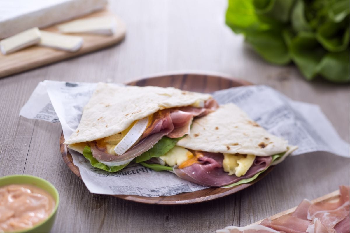 Piadina mit Rohschinken, Brie, Salat und Cocktailsauce