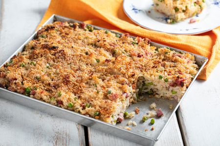 Überbackener Reis mit Käse, Erbsen und Speck