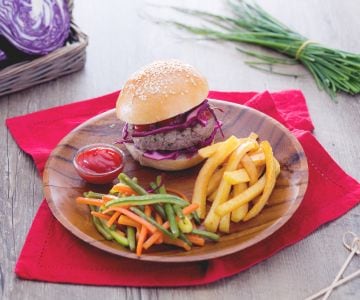Hamburger mit aromatischen Kräutern mit gemischtem Gemüse und Pommes