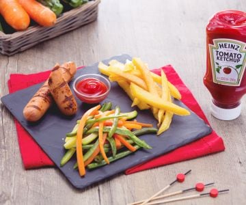 Gegrillte Würstchen mit Pommes Frites und gebratenem Gemüse